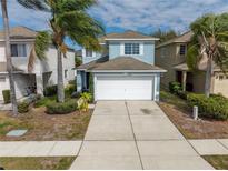 Two-story house with a light blue exterior, a white garage door, and a driveway at 12950 Fennway Ridge Dr, Riverview, FL 33579