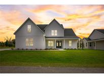 Two-story farmhouse with a front porch, and a neatly landscaped lawn at 32552 Railroad Ave, San Antonio, FL 33576