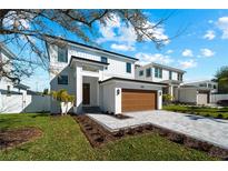 Two-story home with modern design, wood garage door, and landscaped lawn at 2365 Bahia Vista St, Sarasota, FL 34239