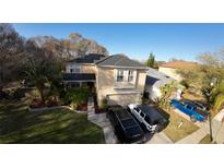 Two-story house with solar panels, landscaped yard, and driveway; located in a residential neighborhood at 4754 Whispering Wind Ave, Tampa, FL 33614