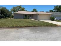 Single-story home with attached garage and well-maintained lawn at 10911 Hachita Dr, Port Richey, FL 34668