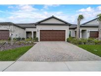 Modern home with a brick driveway and a two-car garage at 31396 Cabana Rye Ave, San Antonio, FL 33576