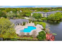 Aerial view of community pool, clubhouse, and surrounding landscape at 4115 Chatham Oak Ct # 218, Tampa, FL 33624