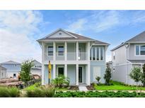 Two-story home with light blue exterior and a front porch at 3659 Tea Leaf Aly, Land O Lakes, FL 34638
