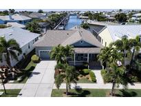 Aerial view showcasing a house with gray-blue exterior, driveway, and landscaping at 406 Islebay Dr, Apollo Beach, FL 33572