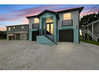 Stunning two-story home featuring a modern design, dual garages, and eye-catching blue accents at 3171 Sea Grape Dr, Hernando Beach, FL 34607