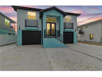 Two-story home with a black roof, garages, balconies, and a striking blue and light-blue color scheme at 3380 Holly Springs Dr, Hernando Beach, FL 34607