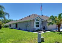 Tan house with brown door, landscaped yard at 2822 Torrance Dr, Land O Lakes, FL 34638