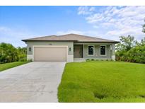Newly constructed home with a light green exterior, a two-car garage, and a well-manicured lawn at 156 Haddock Dr, Rotonda West, FL 33947
