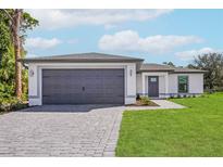 Single-story home with gray garage door and paver driveway at 13371 Drysdale Ave, Port Charlotte, FL 33981