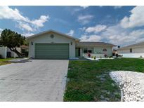 Newly renovated home with a light green garage door and well-manicured lawn at 1508 Fort Duquesna Dr, Sun City Center, FL 33573