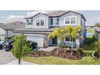 Two-story house with a three-car garage and landscaped front yard at 12964 Willow Grove Dr, Riverview, FL 33579