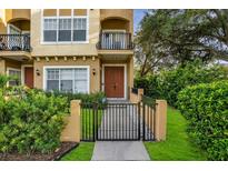 Charming two-story home featuring a front balcony, gated entrance, and lush landscaping at 111 N Albany Ave # 16, Tampa, FL 33606