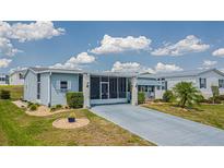 Mobile home with screened porch and landscaped yard at 37607 Neukom Ave, Zephyrhills, FL 33541