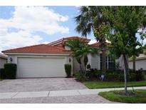 House exterior with a tile roof, landscaping, and driveway at 4922 Sandy Brook Cir, Wimauma, FL 33598