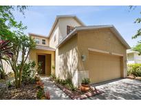Tan two-story house with a two-car garage and landscaping at 17539 Balmaha Dr, Land O Lakes, FL 34638