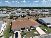 Single story home with a two car garage and lush landscaping at 1607 Cloister Dr, Sun City Center, FL 33573