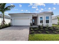 Modern one-story home with a two-car garage and landscaping at 17912 Nadine Pl, Nokomis, FL 34275