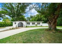 Beautiful mid-century modern home with a landscaped lawn and gated entry at 206 Oakwood Dr, Brooksville, FL 34601