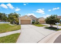 Tan duplex with two-car garages at 30315 Lettingwell Cir, Wesley Chapel, FL 33543