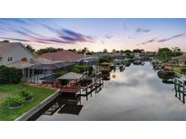 Waterfront property with boat docks on a canal under a vibrant twilight sky at 5510 E Longboat Blvd, Tampa, FL 33615