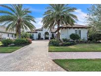 Luxury home with palm trees, brick driveway, and landscaped yard at 15908 Castle Park Ter, Lakewood Ranch, FL 34202