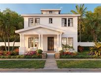 Inviting two-story home featuring a covered porch, complemented by lush landscaping and a well-manicured lawn at 2823 4Th N Ave, St Petersburg, FL 33713