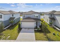 Two-story house with gray siding, white garage door, and a well-manicured lawn at 10619 Hidden Banks Gln, Parrish, FL 34219