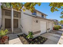 Two-story townhouse with a white garage door and landscaping at 12411 Titus Ct # 12411, Tampa, FL 33612