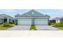 Two-car garage home with light blue exterior and landscaping at 12706 Palatka Dr, Venice, FL 34293