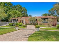 Attractive ranch home with paver driveway, mature landscaping, and fenced yard at 401 Appian Ne Way, St Petersburg, FL 33704