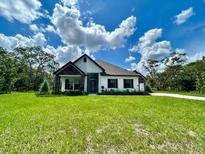 Inviting single-story home featuring stone accents and a well-manicured lawn at 13530 Oldenburg Dr, Hudson, FL 34667