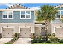 Charming two-story home with blue siding, double garage, and landscaped yard at 11522 Cambium Crown Dr, Riverview, FL 33569