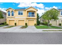 Two-story townhome with a two-car garage and a balcony at 9107 Moonlit Meadows Loop, Riverview, FL 33578
