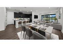 Bright open-concept living space with dark kitchen cabinets and a dining area overlooking the screened porch at 3778 Maxwell Park Dr, Sun City Center, FL 33573