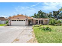 Charming home with a two-car garage, stone accents, and manicured lawn enhancing curb appeal in a lovely neighborhood at 2115 Seagull Dr, Clearwater, FL 33764