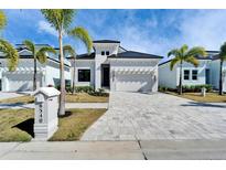 Stunning two-story home featuring a paved driveway, minimalist landscaping, and a two-car garage at 6540 Simone Shores Cir, Apollo Beach, FL 33572