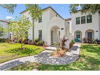 Charming two-story home featuring a stucco facade, arched entryway, and lush landscaping at 4606 W Fig St # 4, Tampa, FL 33609