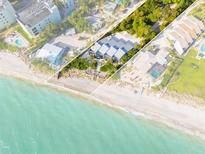 Aerial view of beachfront property with private beach access, and a modern three-unit building at 5030 N Beach Rd # 2, Englewood, FL 34223