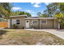 Mid-century modern home with a light-colored facade and well-maintained lawn at 7310 11Th N Ave, St Petersburg, FL 33710