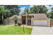 Charming single-story home boasts a well-manicured lawn, mature trees, and an attached two-car garage at 3501 Country Creek Ln, Valrico, FL 33596