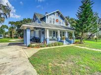 Blue house with a wrap-around porch, white picket fence, and a large yard at 510 Tighe Ave, Seffner, FL 33584