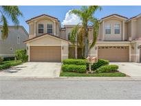 Two-story townhome with attached garage and manicured lawn at 10426 La Mirage Ct, Tampa, FL 33615