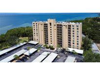 Aerial view of waterfront condo building with parking and water access at 2616 Cove Cay Dr # 506, Clearwater, FL 33760