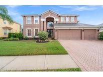 Two-story home with attractive landscaping and a brick driveway at 21631 Cormorant Cove Dr, Land O Lakes, FL 34637