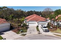 Beautiful exterior of a home with a red tile roof, manicured landscaping, and a two car garage at 10263 Devonshire Lake Dr, Tampa, FL 33647