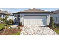 Charming single-story home featuring a two-car garage and a patterned paver driveway at 9413 Ballaster Pointe Loop, Parrish, FL 34219