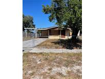 House exterior with boarded windows and chain link fence at 10007 N 26Th St, Tampa, FL 33612