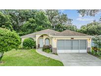 One-story home with screened garage and landscaped yard at 6928 Stephens Path, Zephyrhills, FL 33542
