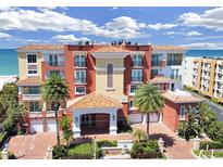 Beautiful condominium building with a red tile roof, palm trees, and ocean views at 16300 Gulf Blvd # 300B, Redington Beach, FL 33708